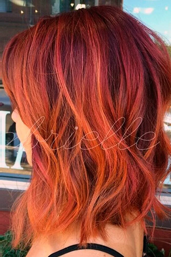Back-side view of a short copper layered cut with orange-red ribbons and flicked ends