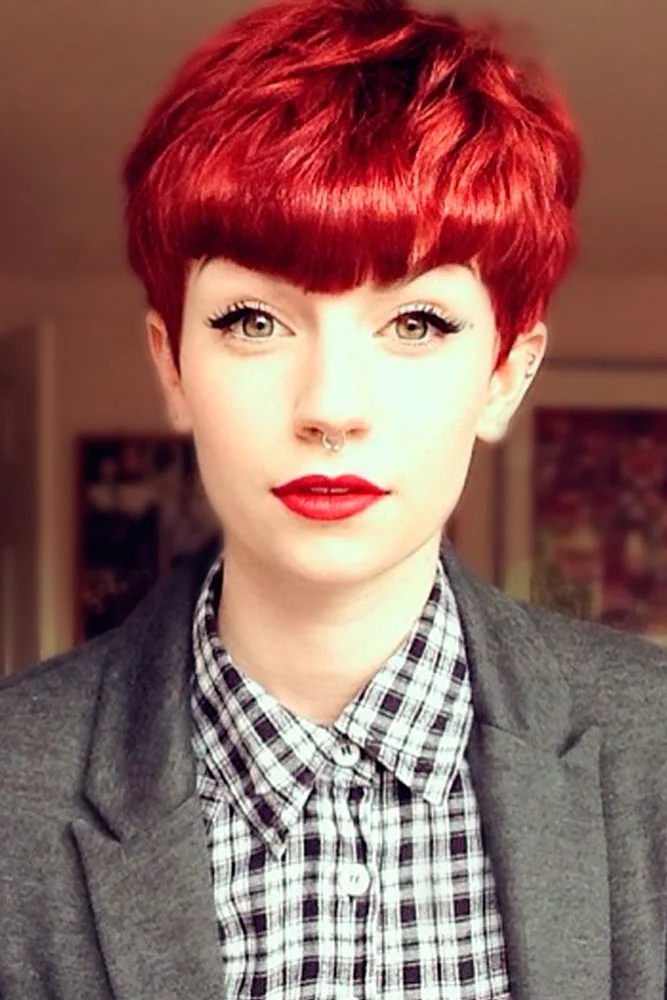 Front portrait of a short cherry-red pixie with a straight full fringe and close-cut sides