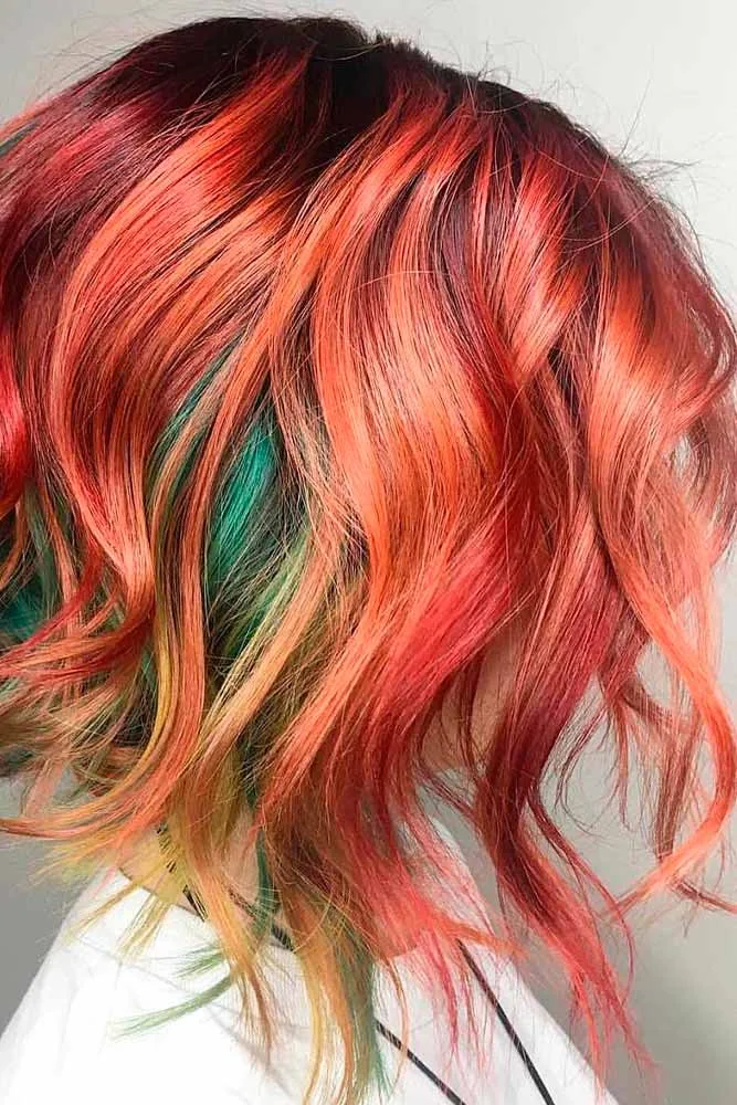 Side view of short copper-orange waves with a few teal-green strands through the lower layers