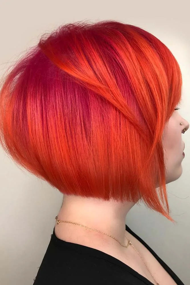 Side view of a short rounded blunt bob colored bright orange-red with a longer front point
