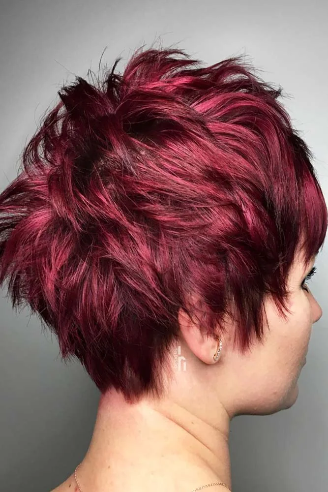 Back-side view of a short layered pixie colored dark raspberry red with tousled crown pieces