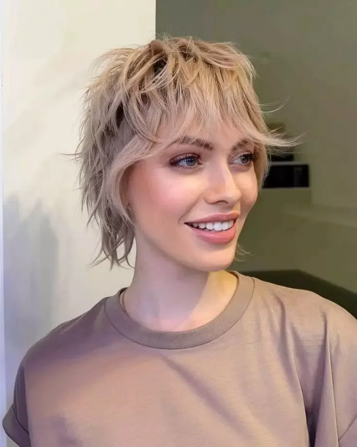 Soft blonde pixie shag with short layers and airy bangs