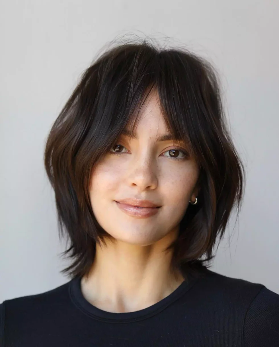Dark short wolf cut with soft curtain bangs and layered cheekbone pieces