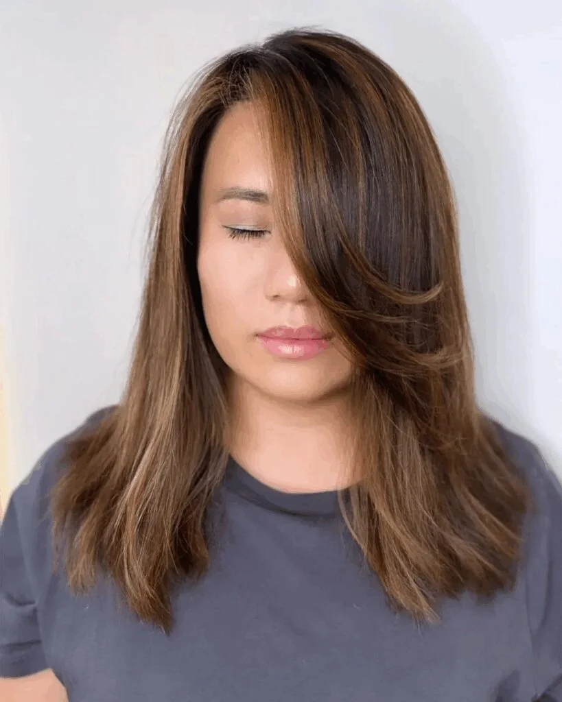 Smooth side-swept shoulder length cut for thin fine hair with long face framing