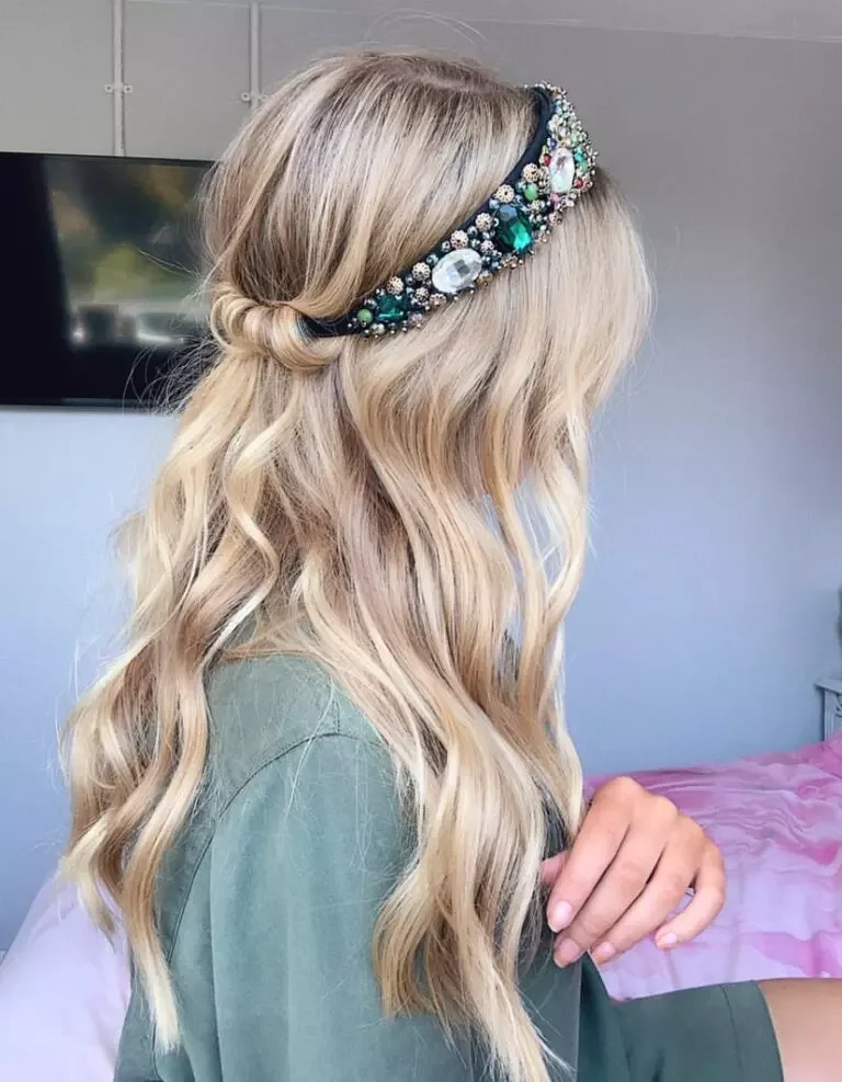 chest curly brunette bun shown as a simple wedding guest hair idea