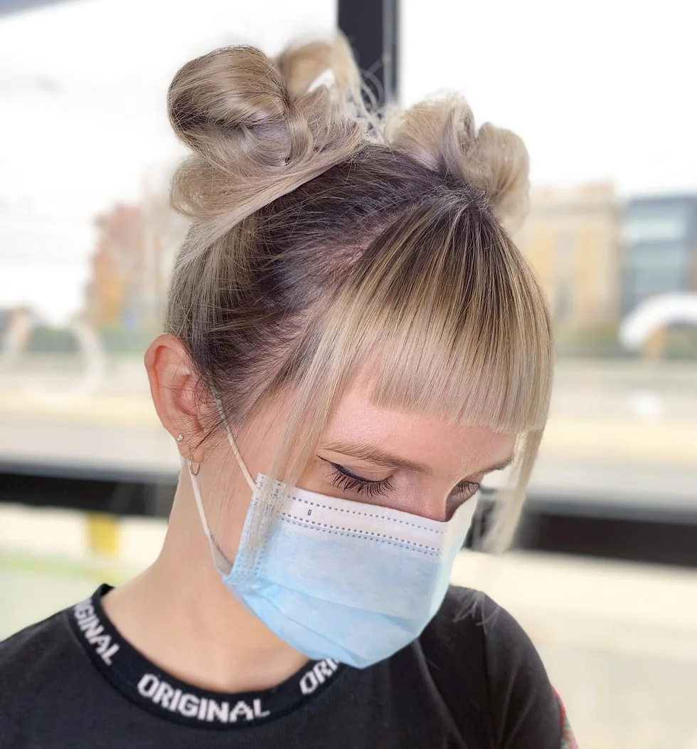 shoulder straight blonde bun with wispy fringe shown as a space buns idea