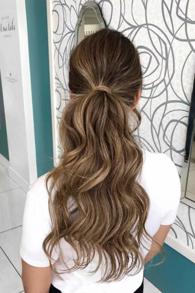 Back view of brown hair gathered low with a long loose wavy ponytail