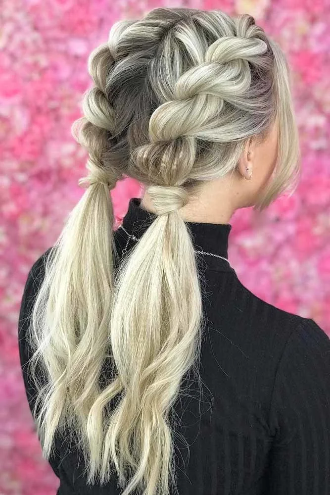 Back-side view of two broad crown braids ending in separate low ponytails
