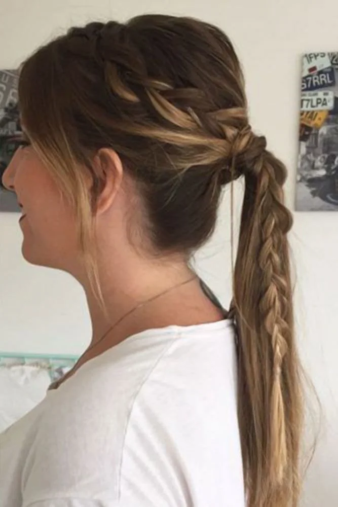 Side view of a low ponytail with a swept-back side section and a braided upper tail ending in loose hair