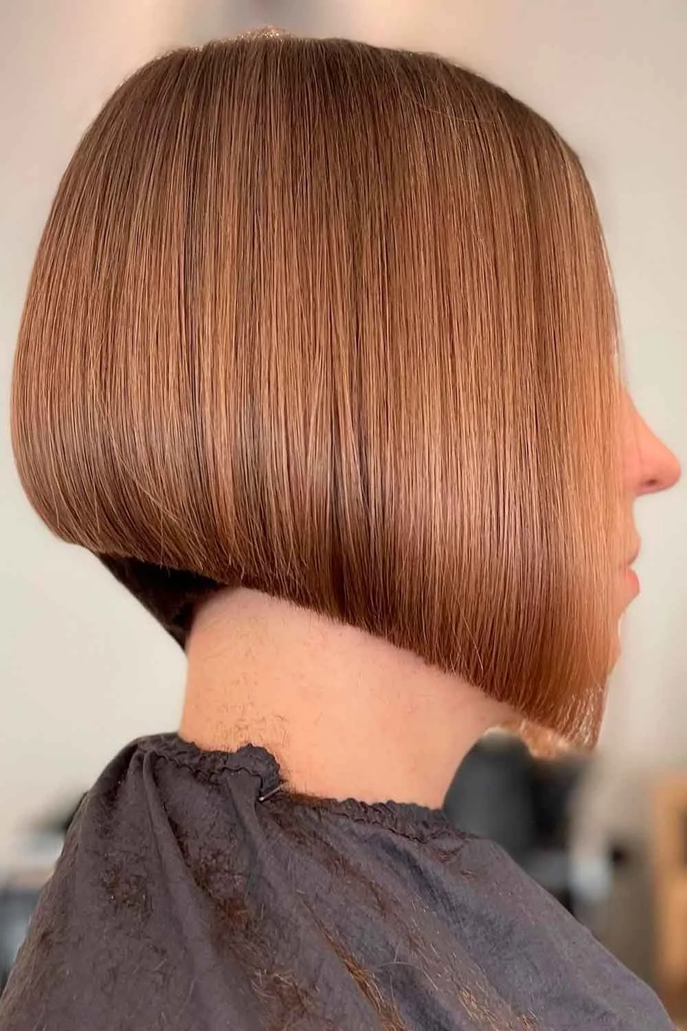 Side view of a smooth copper bob with a rounded back and longer front edge