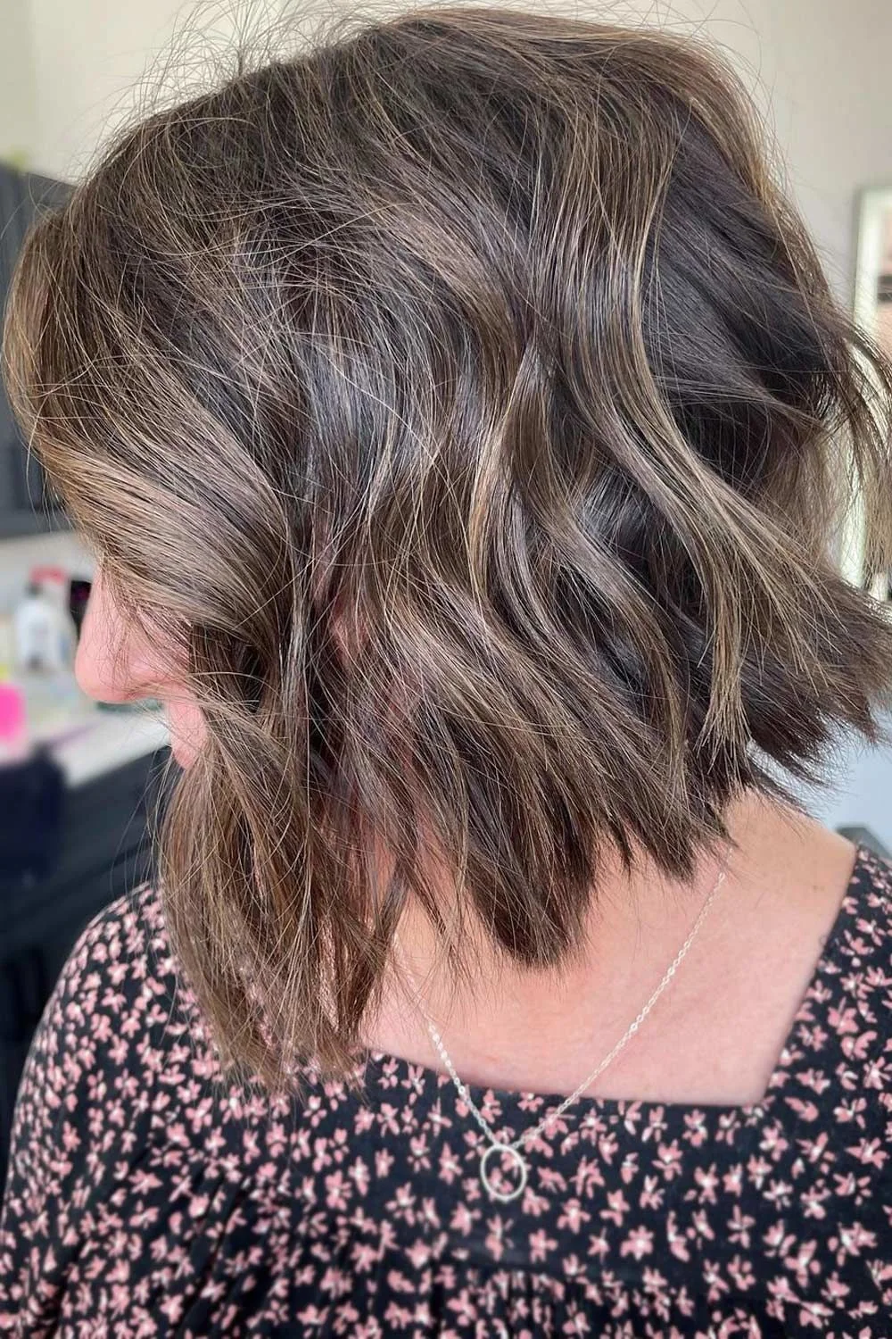 Side-back view of a brown bob with loose waves and a rounded short nape