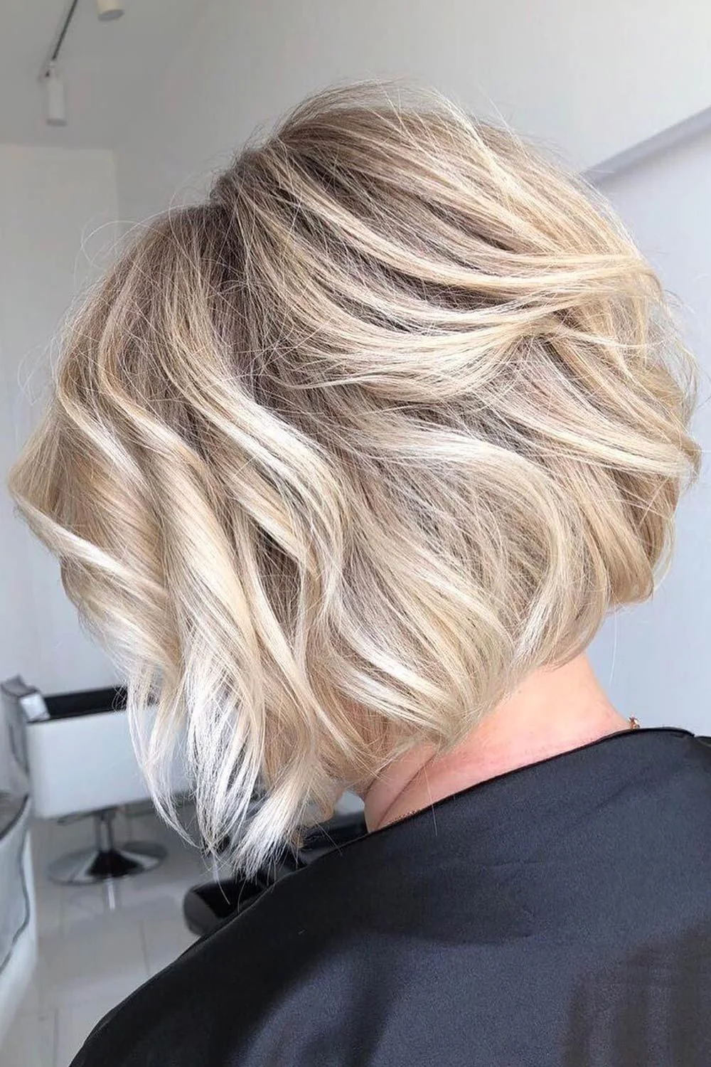Back-side view of a blonde bob with broad waves above a short nape
