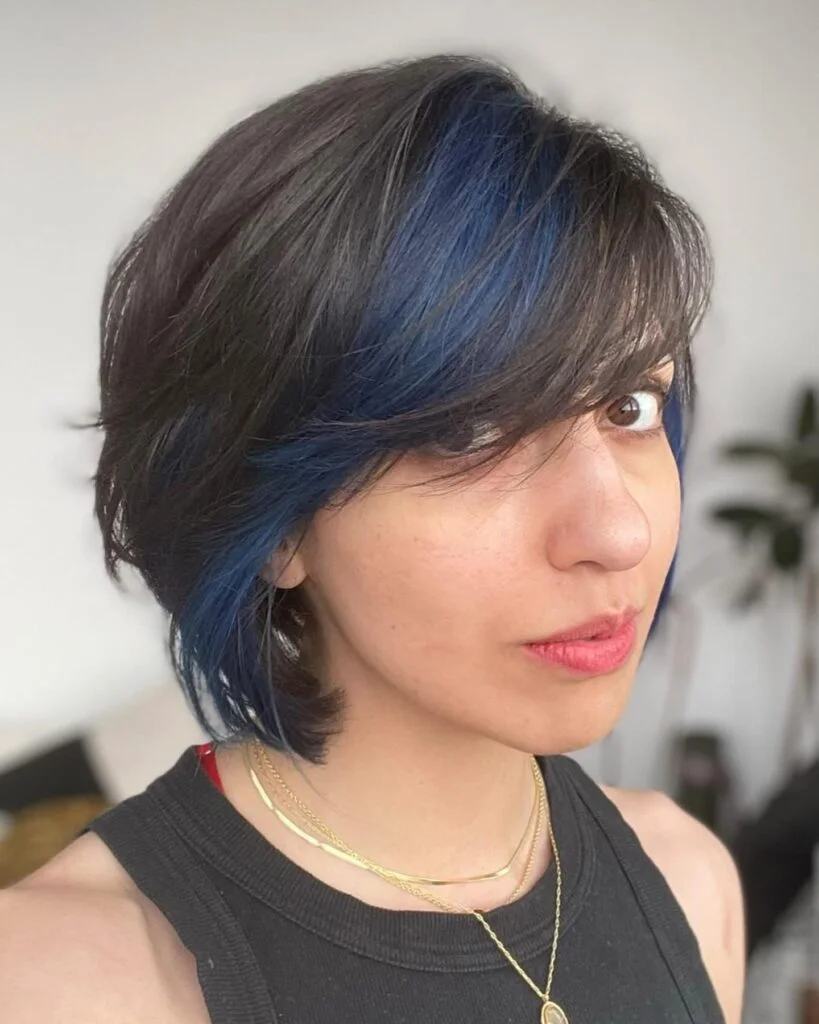 ear straight golden pixie with wispy fringe shown as a thin hairstyles with bangs idea, featuring textured finish, shown in blue-accent pixie with side bangs