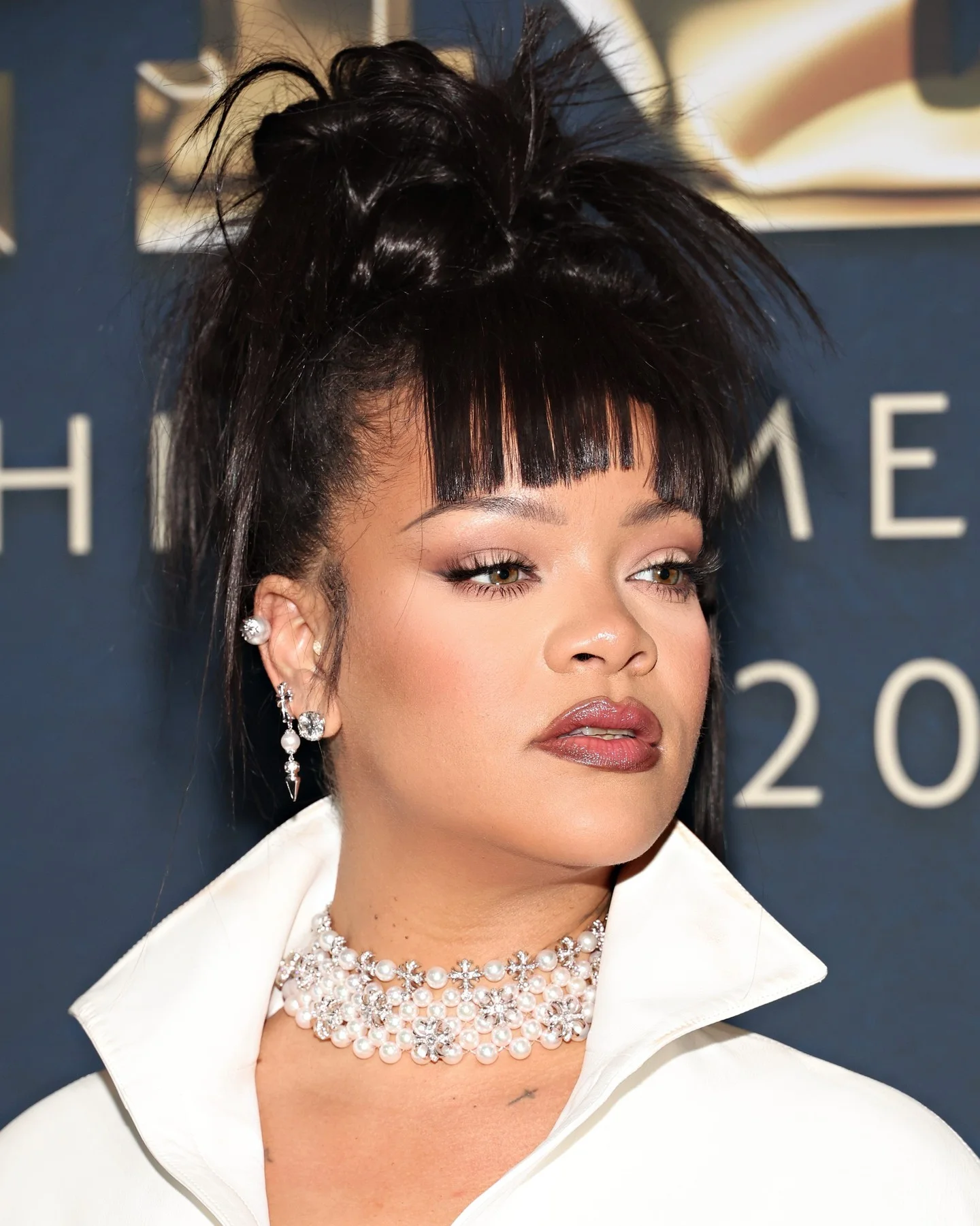 polished high updo with micro fringe with black curly hair styled as an updo for fine thin hair