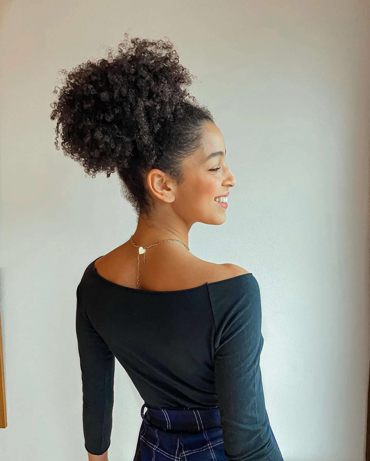 soft curly high updo with black coily hair styled as an updo for fine thin hair