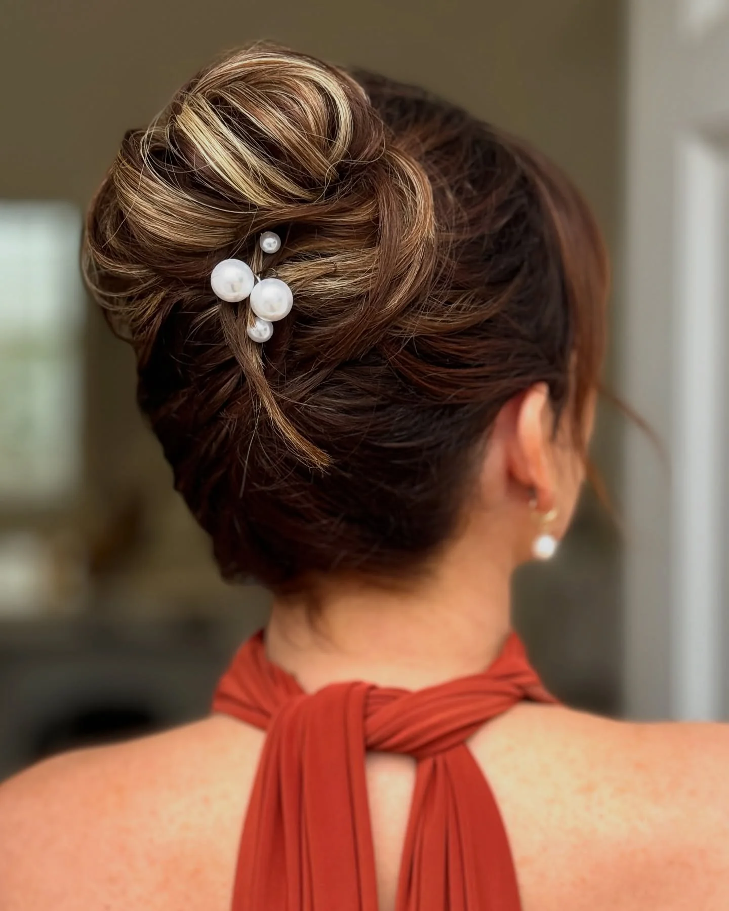 pearl pin low updo with brunette wavy hair styled as an updo for fine thin hair