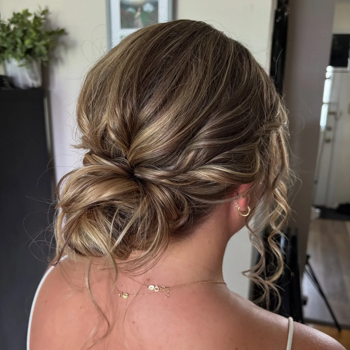 loose textured low bun with blonde wavy hair styled as an updo for fine thin hair