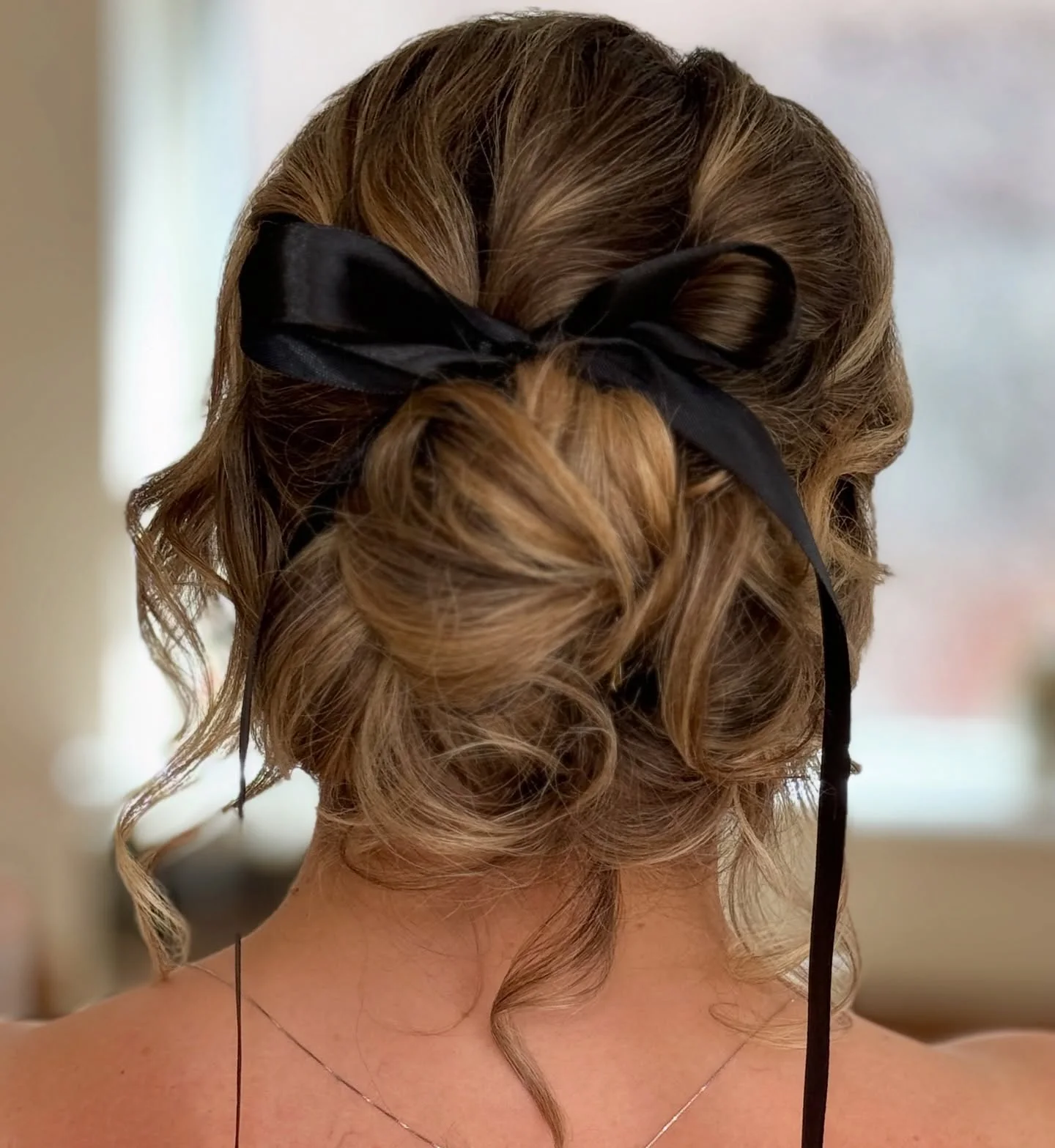 ribbon textured low updo with brunette wavy hair styled as an updo for fine thin hair