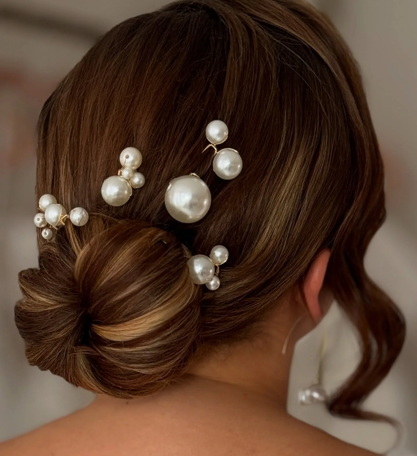 shoulder wavy blonde updo shown as a wedding guest hairstyle idea, featuring side part