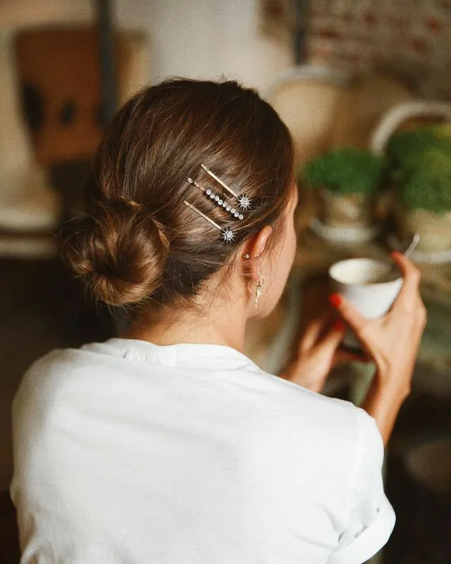 shoulder wavy blonde updo shown as a wedding guest hairstyle idea, featuring medium layering