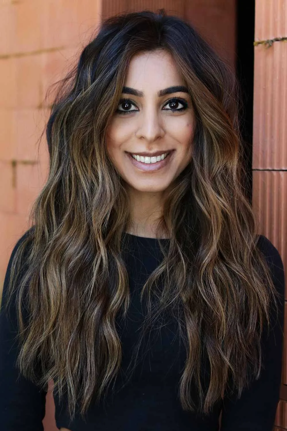 Long dark brown layers with narrow cool ash-brown highlights around the face and through the ends